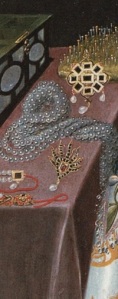 A detail from an early portrait of Elizabeth Vernon, showing an open jewellery box, a lavish display of pearls, brooches etc, and a pincushion containing the pins grand Elizabethan ladies used to hold their formal attire together. 